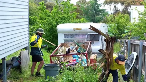 Reliable residential junk removal service clearing out clutter, old appliances, and boxes from a home garage.